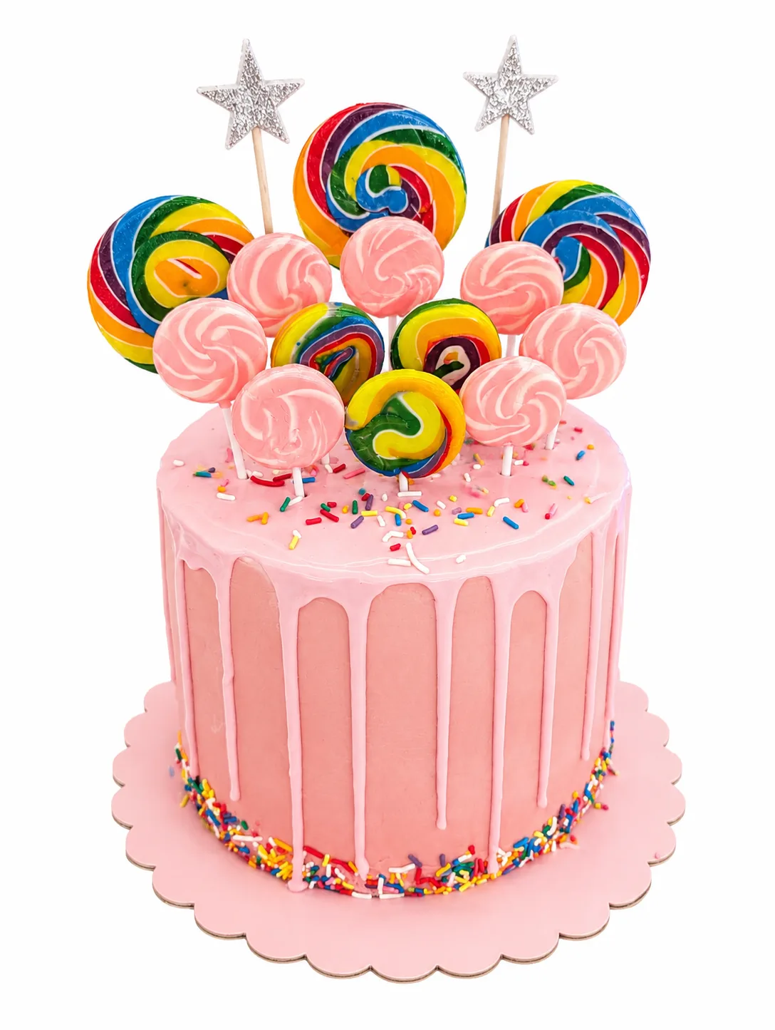 Pink drip cake decorated with rainbow lollipops and colourful candy swirls