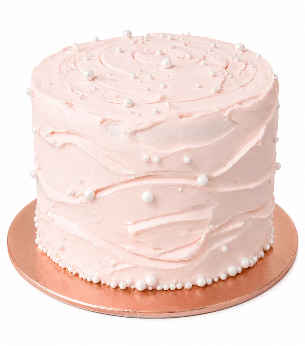 Soft blush buttercream cake with elegant pearl accents